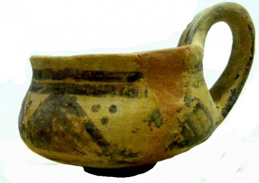 Handmade dipper cup in refined clay, restored, decorated with a matt-painted frieze of crosshatched triangles. From the excavations Stoop 1963-69 on the Acropolis of the Timpone della Motta. Height 7.9cm, diameter at rim 8.3cm. Middle Geometric period. Archaeological Museum of the Sibaritide, No. 64700. Handmade dipper cup in refined clay, restored, decorated with a matt-painted frieze of crosshatched triangles. From the excavations Stoop 1963-69 on the Acropolis of the Timpone della Motta. Height 7.9cm, diameter at rim 8.3cm. Middle Geometric period. Archaeological Museum of the Sibaritide, No. 64700.
